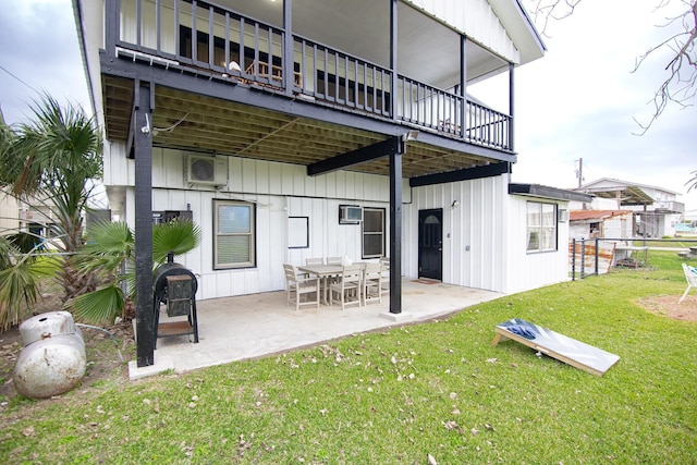 rear view of house with a lawn, a balcony, and a patio