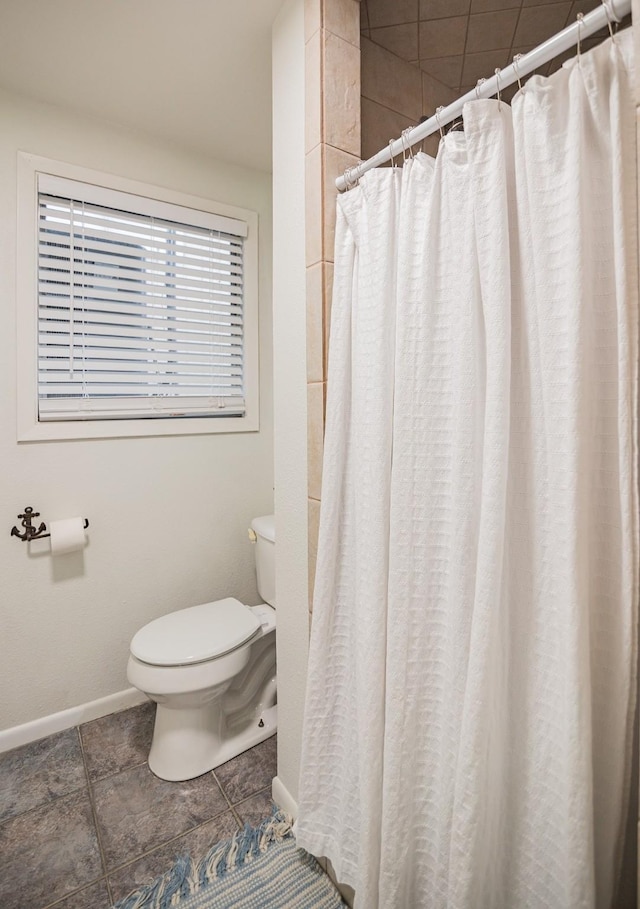 bathroom featuring a shower with curtain and toilet