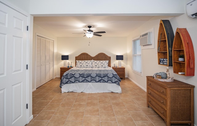 tiled bedroom with a closet, an AC wall unit, and ceiling fan