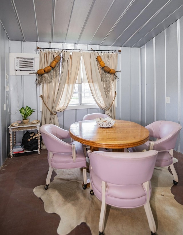 dining room with an AC wall unit and concrete flooring