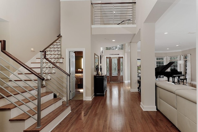 foyer featuring a towering ceiling and dark hardwood / wood-style floors