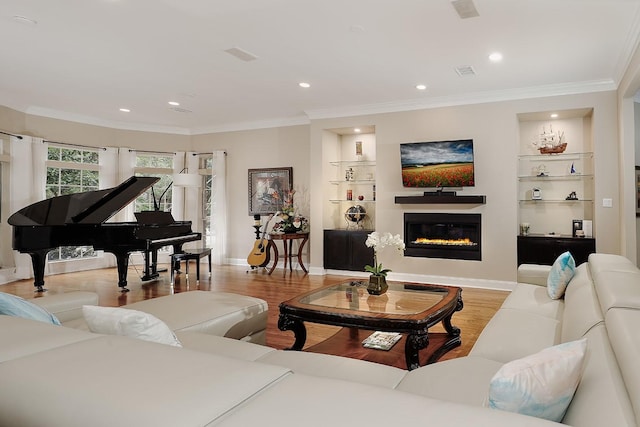 living room featuring built in shelves, light wood-type flooring, and crown molding