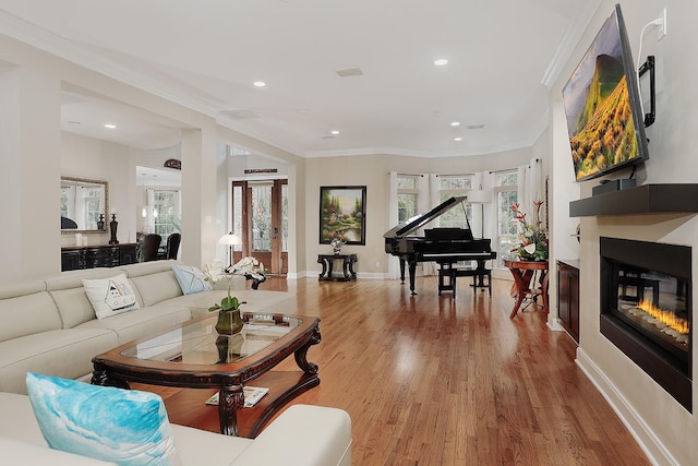 living room with french doors, light hardwood / wood-style floors, and ornamental molding