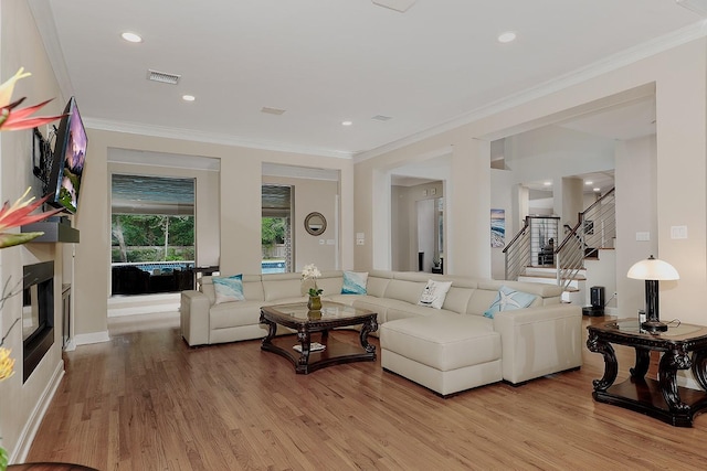 living room with crown molding and light hardwood / wood-style flooring