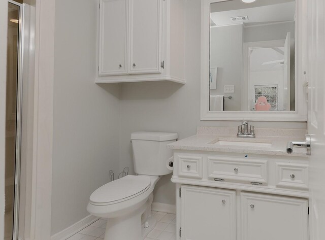 bathroom with toilet, vanity, and tile patterned floors