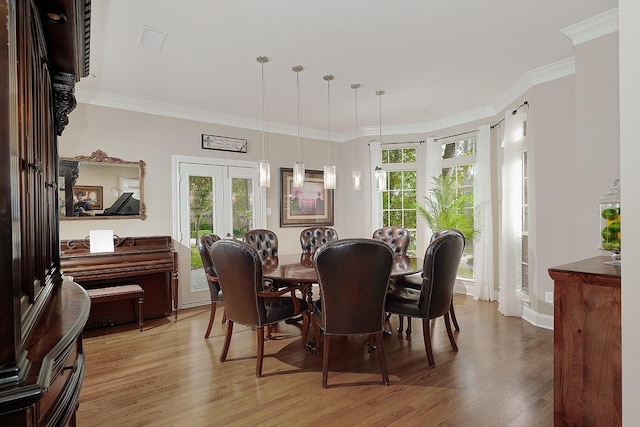 dining space featuring hardwood / wood-style floors and ornamental molding