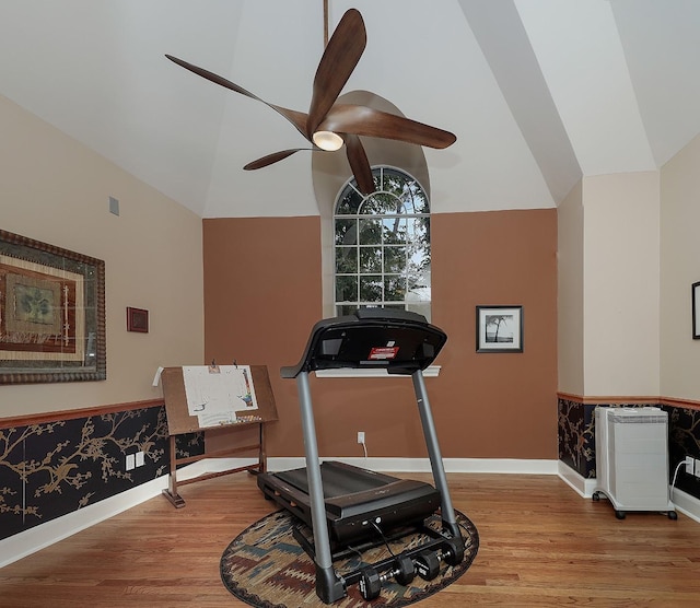 exercise area featuring ceiling fan, light wood-type flooring, and lofted ceiling