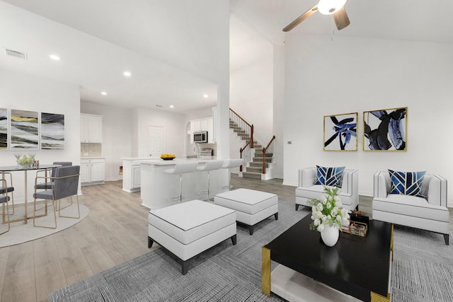 living room featuring ceiling fan and light hardwood / wood-style flooring