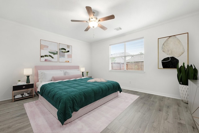 bedroom with ceiling fan, wood-type flooring, and ornamental molding