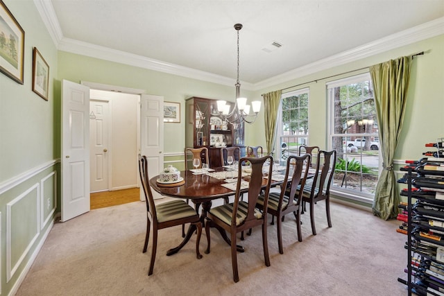 dining space featuring light colored carpet, crown molding, and a chandelier