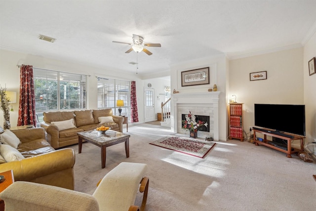 carpeted living room featuring ceiling fan, a fireplace, and ornamental molding