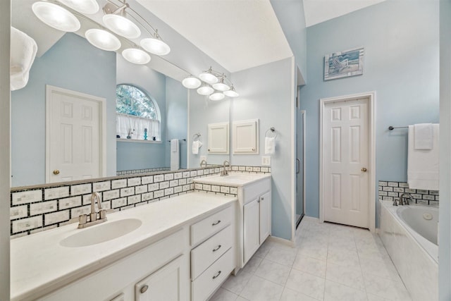 bathroom featuring tile patterned floors, decorative backsplash, vanity, and tiled bath