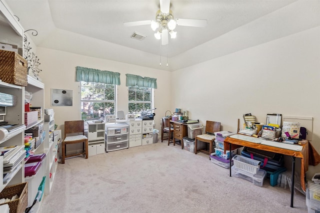 office area featuring carpet flooring, ceiling fan, and a tray ceiling