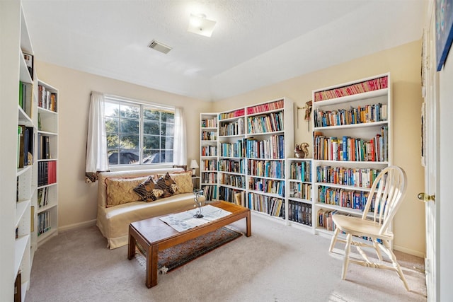 living area featuring carpet flooring, a textured ceiling, and vaulted ceiling