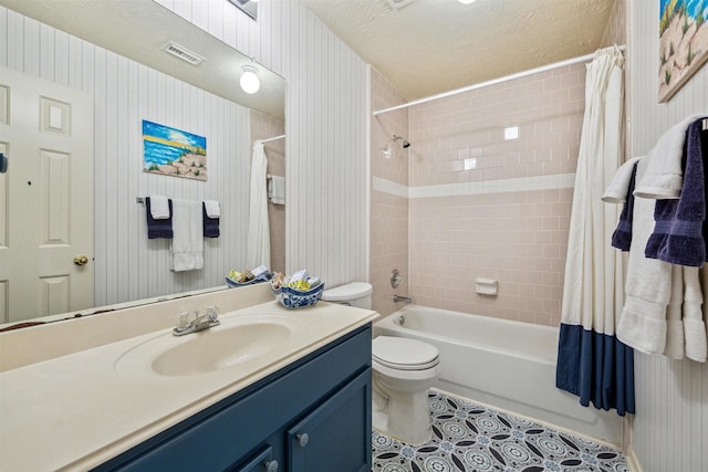 full bathroom with shower / bathtub combination with curtain, tile patterned flooring, a textured ceiling, toilet, and vanity