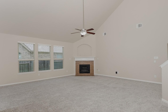 unfurnished living room featuring a tiled fireplace, light carpet, high vaulted ceiling, and ceiling fan