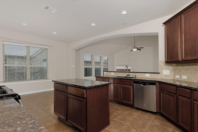 kitchen with dishwasher, dark stone countertops, sink, and black stove