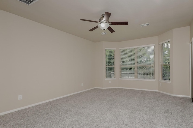 carpeted spare room featuring ceiling fan