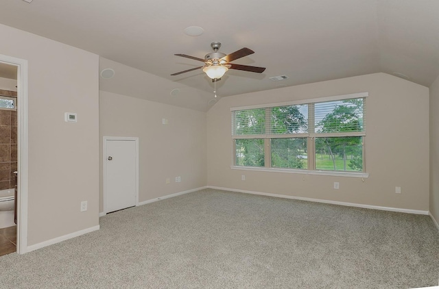 empty room with ceiling fan, carpet floors, and vaulted ceiling