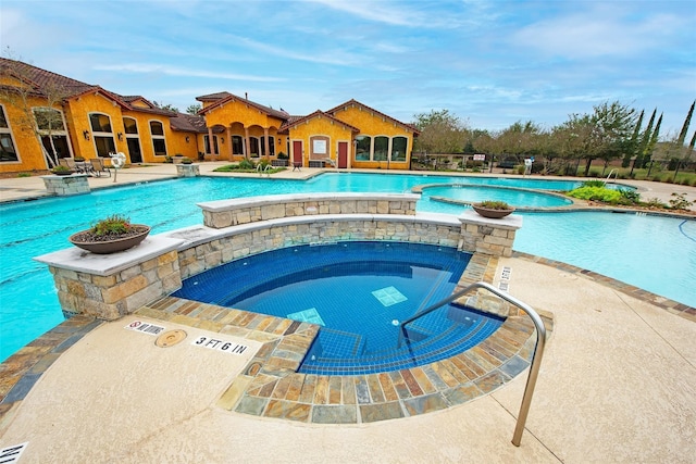 view of pool featuring pool water feature and a community hot tub