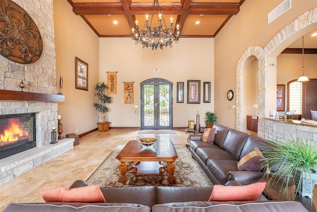 living room featuring a stone fireplace, a towering ceiling, beamed ceiling, and coffered ceiling