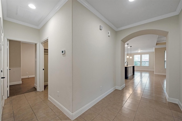 hall featuring crown molding and light tile patterned floors