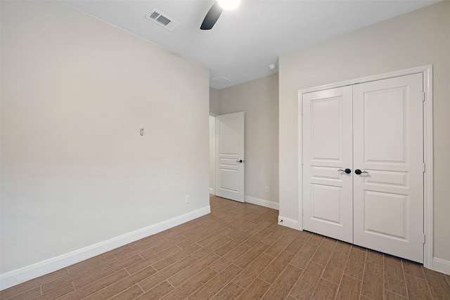 unfurnished bedroom with ceiling fan and a closet