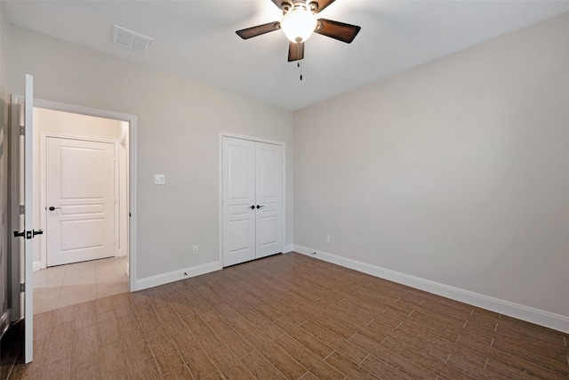 unfurnished bedroom with ceiling fan and a closet