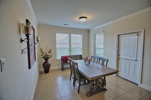 tiled dining room with a textured ceiling and ornamental molding