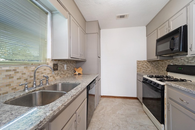 kitchen featuring light stone countertops, sink, white cabinetry, backsplash, and black appliances