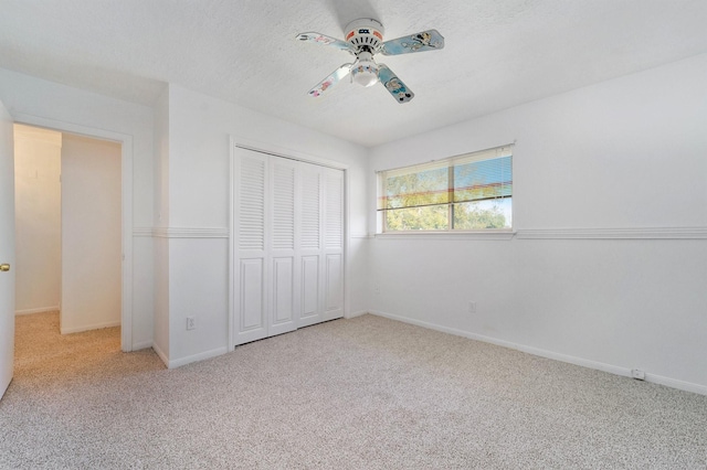 unfurnished bedroom featuring ceiling fan, a closet, carpet, and a textured ceiling