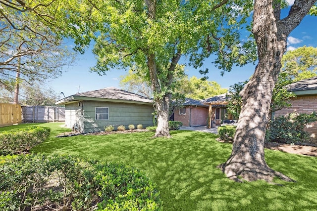 rear view of property with a lawn and fence