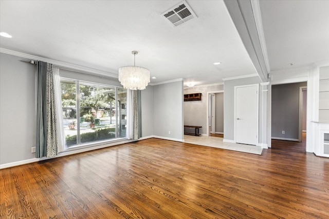 unfurnished living room featuring a chandelier, hardwood / wood-style flooring, and crown molding