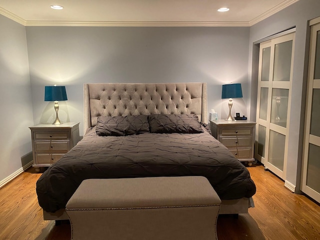 bedroom with crown molding, light wood-style flooring, and baseboards