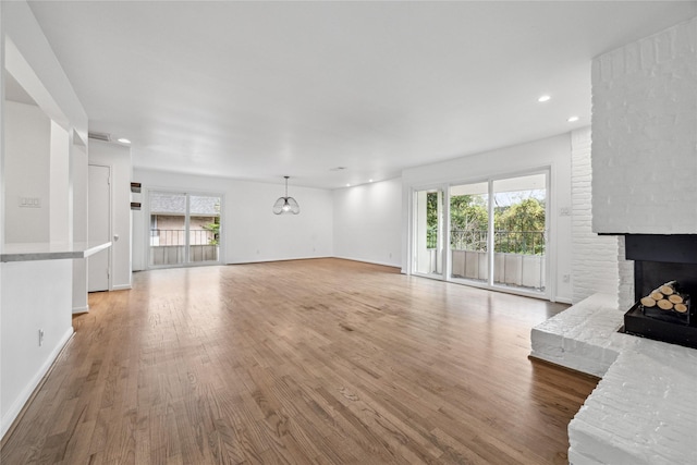 unfurnished living room featuring light hardwood / wood-style flooring and a fireplace