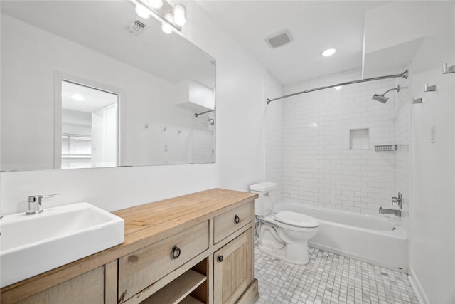 full bathroom featuring tiled shower / bath, vanity, and toilet