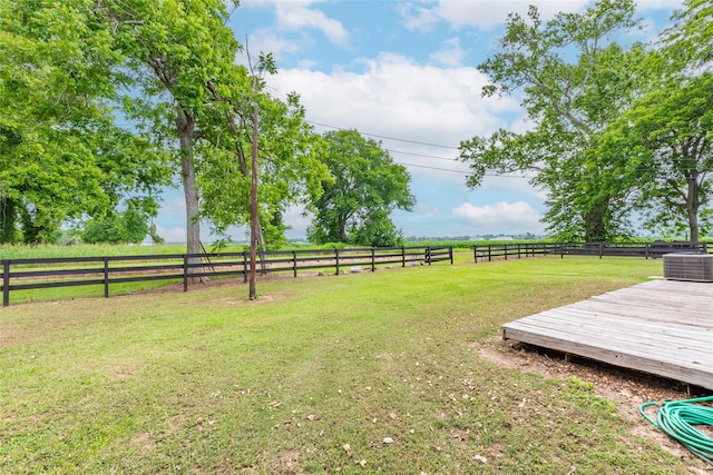 view of yard featuring a rural view, a wooden deck, and central AC