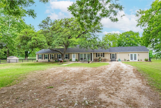 ranch-style home featuring a front yard and french doors