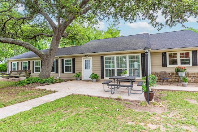 rear view of property featuring a yard and a patio