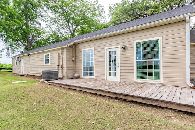 back of house with a deck, cooling unit, and a lawn