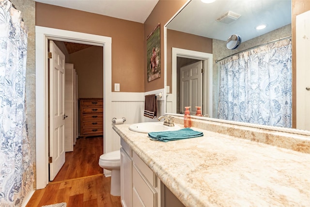 bathroom featuring a shower with shower curtain, vanity, hardwood / wood-style flooring, and toilet