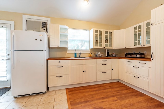 kitchen featuring a wealth of natural light, sink, lofted ceiling, and white refrigerator