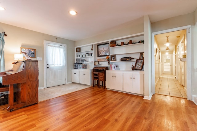 kitchen featuring built in shelves, white cabinets, and light hardwood / wood-style floors