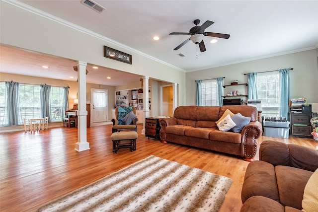 living room with ceiling fan, light hardwood / wood-style floors, crown molding, and decorative columns