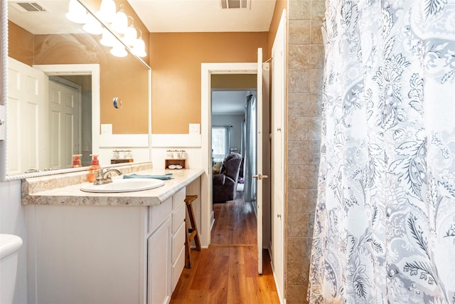 bathroom with toilet, hardwood / wood-style floors, vanity, and a shower with curtain