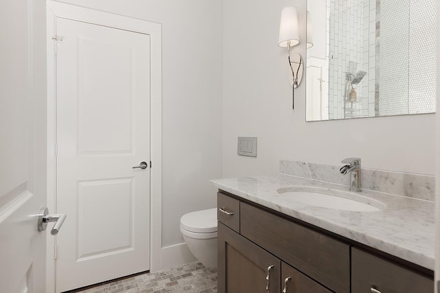 bathroom featuring a shower, vanity, and toilet