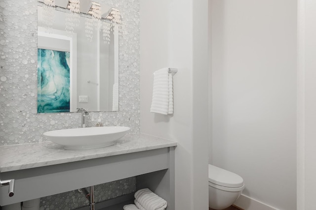 bathroom featuring decorative backsplash, toilet, and vanity