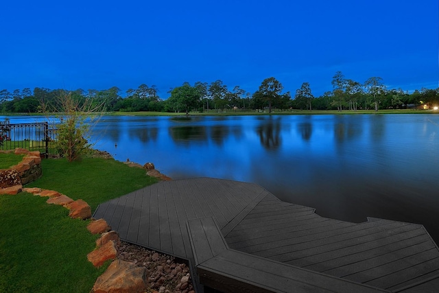 view of dock featuring a water view and a yard