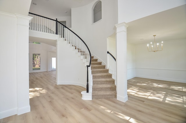 stairway featuring ornamental molding, a chandelier, and wood-type flooring