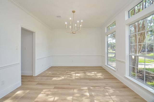 unfurnished dining area with light hardwood / wood-style floors, an inviting chandelier, and ornamental molding